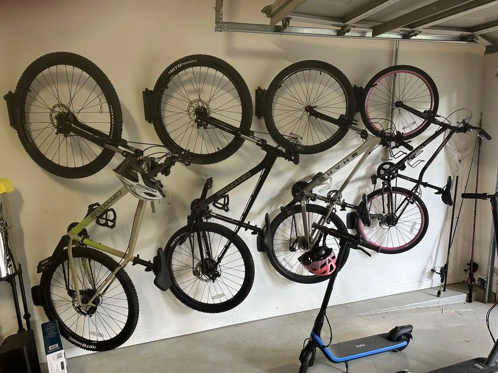 Bicycles organized on wall-mounted storage racks in a garage
