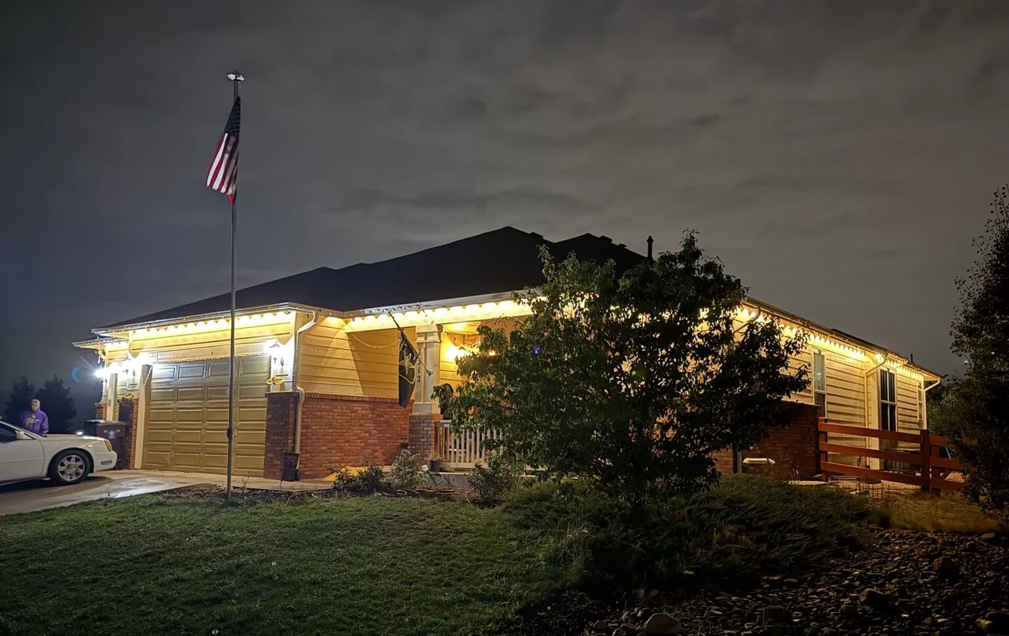 Warm roofline lighting installed on a home at dusk